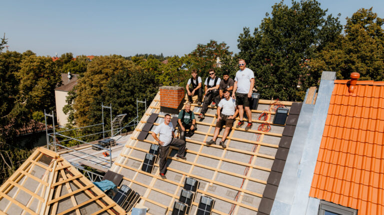 Dachbau, Gruppe von Dachdeckern auf ungedecktem Hausdach