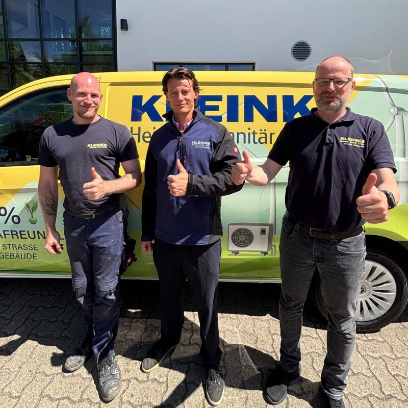 Gruppe von drei Handwerkern der Firma Kleinke vor Servicemobil